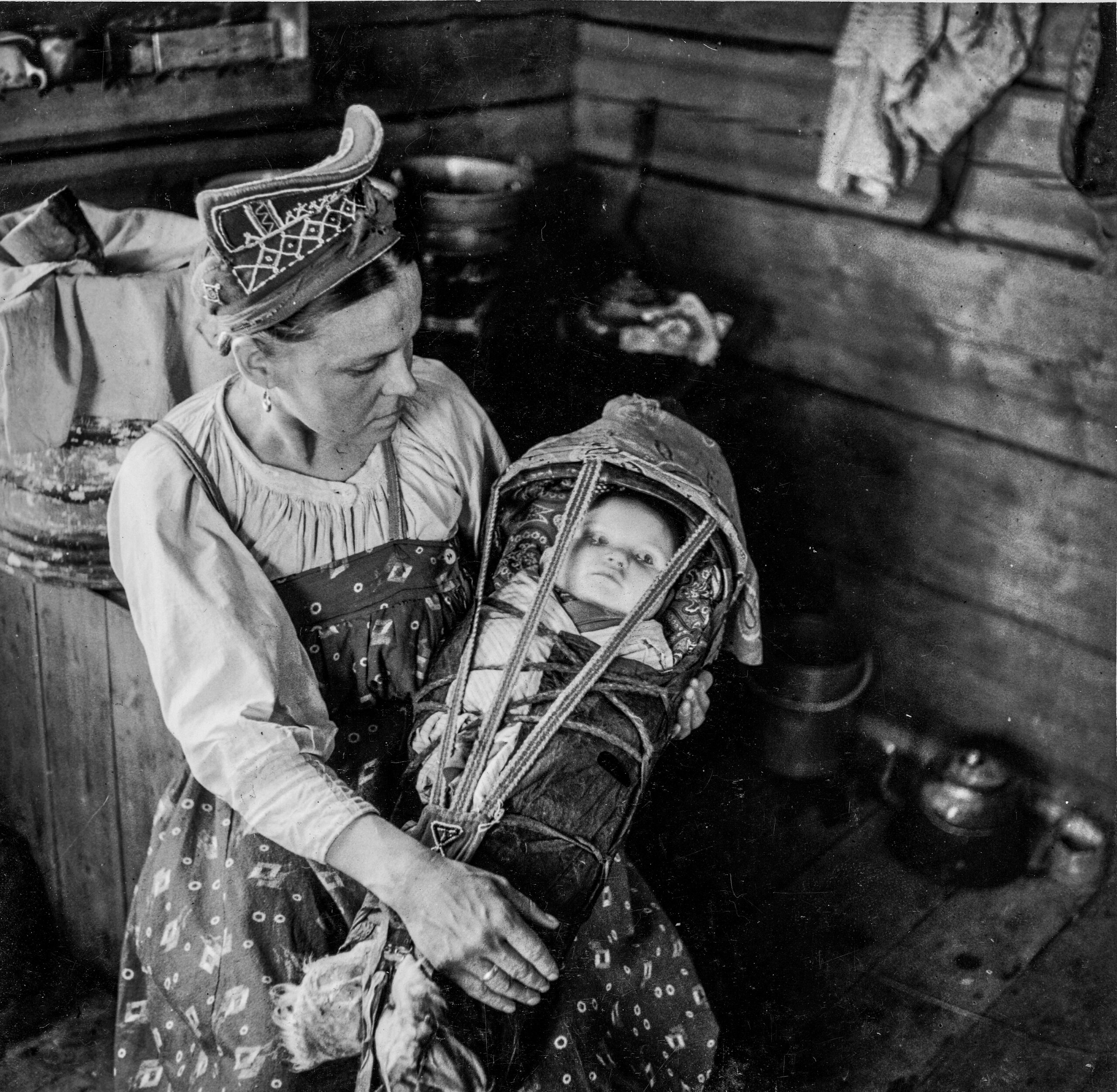 Skolt Sami Woman Holding Her Child In A Ǩiõtkâm